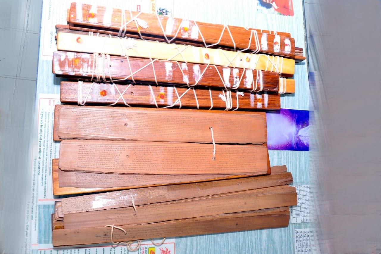 Cabinet of preserved Nadi palm-leaf manuscript bundles, garlanded
